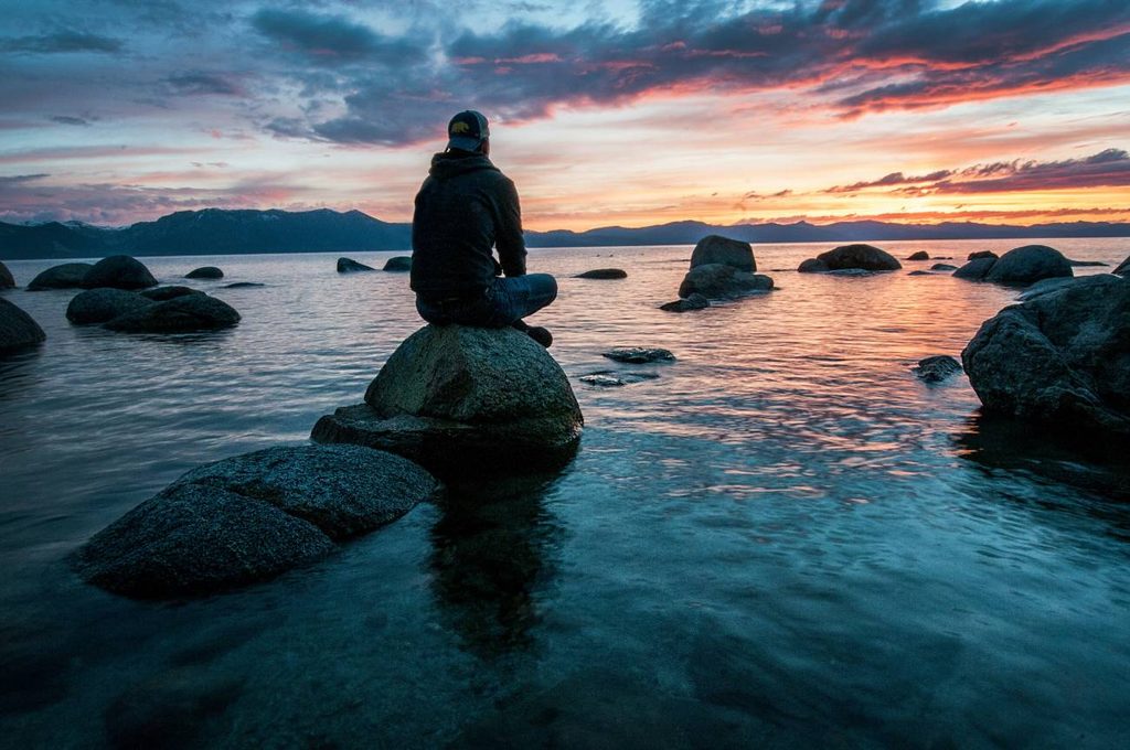 景色のいい夕方の海で、ひとりたそがれる男性